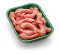 Raw chicken necks in a green tray over white background