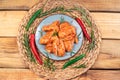 Raw chicken pickled wings on a blue round plate with red hot pepper on a wooden background. Raw chicken marinated meat. Grilled Royalty Free Stock Photo