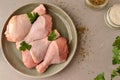 Raw chicken in a plate. Marinated meat, with oregano, herbs and paprika. Raw chicken legs, step by step cooking. Top view, gray