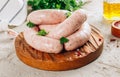 Raw chicken sausage for grilled on wooden cutting board with parsley.