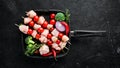 Raw chicken shish kebab with cherry tomatoes. Barbecue. On a black stone background. Royalty Free Stock Photo