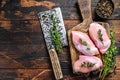 Raw Chicken skinless thigh fillet on a wooden cutting board. Black background. Top view. Copy space Royalty Free Stock Photo
