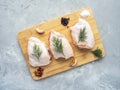 Raw chicken thighs on cutting board with ingredients for cooking at grey concrete kitchen table. Top view with copy Royalty Free Stock Photo