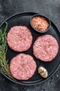 Raw chicken turkey patty, minced meat cutlets on a plate with thyme. Black background. Top view