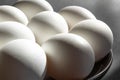 Raw chicken white eggs in a black bowl on dark background