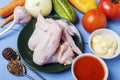 Raw chicken wings for cooking meat dishes. Fresh mayonnaise, tomato sauce and organic vegetables from rustic garden for garnish. H Royalty Free Stock Photo