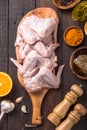 Raw chicken wings with ingredients for cooking: hohey, orange fruit, garlic, olive oil, kari on a wooden cutting board over