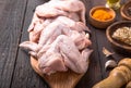 Raw chicken wings with ingredients for cooking: hohey, orange fruit, garlic, olive oil, kari on a wooden cutting board over