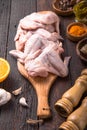 Raw chicken wings with ingredients for cooking: hohey, orange fruit, garlic, olive oil, kari on a wooden cutting board over