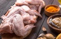 Raw chicken wings with ingredients for cooking: hohey, orange fruit, garlic, olive oil, kari on a wooden cutting board over