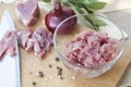 Raw chopped pork tenderloin with herbs in a glass bowl on a wooden board Royalty Free Stock Photo