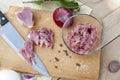 Raw chopped pork tenderloin with herbs in a glass bowl on a wooden board Royalty Free Stock Photo