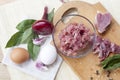 Raw chopped pork tenderloin with herbs in a glass bowl on a wooden board Royalty Free Stock Photo