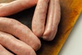 Raw classic British sausage made from prime cuts of pork on the wooden board