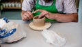 A raw clay pot in the hands of a potter. Workshop in the pottery workshop.