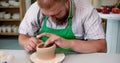 A raw clay pot in the hands of a potter. Workshop in the pottery workshop. Royalty Free Stock Photo