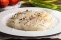 Raw cod with crushed pepper on a plate