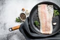 Raw cod fillet with thyme and herbs in a pan. Cooking fresh fish. Gray background. Top view. Copy space Royalty Free Stock Photo