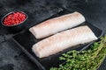 Raw cod loin fillet fish on marble board. Black background. Top view Royalty Free Stock Photo