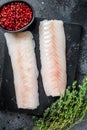 Raw cod loin fillet fish on marble board. Black background. Top view Royalty Free Stock Photo