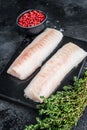 Raw cod loin fillet fish on marble board. Black background. Top view Royalty Free Stock Photo