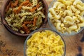 Multicolor spiral macaroni Wooden white and glass bowl with pasta on a textured wooden board, close-up view from the top Royalty Free Stock Photo