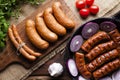 Raw and cooked sausage, pan, herbs and vegetables Royalty Free Stock Photo