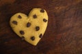 Raw cookie dough with chocolate chips in the shape of a heart on a wooden background. Royalty Free Stock Photo