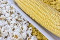 Raw corn cob, popcorn and cornflakes closeup