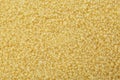Raw couscous grains as background, top view