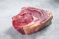 Raw cowboy steak or rib eye on the bone. Marble beef. Gray background. Top view Royalty Free Stock Photo