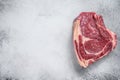 Raw cowboy steak or rib eye on the bone. Marble beef. Gray background. Top view. Copy space Royalty Free Stock Photo