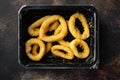 Raw Crispy deep fried onion or Calamari ring plastic pack, on old dark rustic table background, top view flat lay Royalty Free Stock Photo