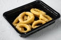 Raw Crispy deep fried onion or Calamari ring plastic pack, on white stone table background Royalty Free Stock Photo