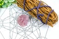 Raw crystal healing rose quartz and white sages herb sticks for clearing negative energy on Metraton cube. Mind and soul spirit. Royalty Free Stock Photo
