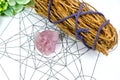 Raw crystal healing rose quartz and white sages herb sticks for clearing negative energy on Metraton cube. Mind and soul spirit.