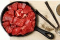 Raw Cubed Beef in Cast Iron Skillet on Table Royalty Free Stock Photo
