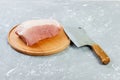 Raw cut of pork shoulder on board with knife or Kitchen ax. cleaver with fresh raw meat on black wooden background Royalty Free Stock Photo