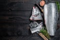 Raw cut salmon fish on a wooden cutting board with chef cleaver. Black Wooden background. Top view. Copy space