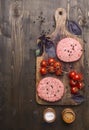 Raw cutlet for burgers, with cherry tomatoes and herbs on a cutting board, boarder, space for text wooden rustic background top