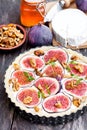 Raw delicious tart with fresh figs and goat cheese on rustic wo Royalty Free Stock Photo