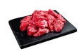 Raw diced red beef meat for Goulash on marble board. Isolated on white background. Top view. Royalty Free Stock Photo