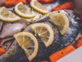 Raw dorado fish with spices lemon and vegetables, cooking on baking tray. Royalty Free Stock Photo