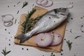 Raw dorado fish, spices and onion on white wooden table