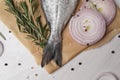 Raw dorado fish, spices and onion on white wooden table, flat lay