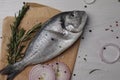 Raw dorado fish, spices and onion on white wooden table, flat lay