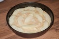 Raw dough with apple slices on wooden table, closeup. Baking pie Royalty Free Stock Photo