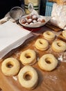 Raw dough donuts prepared on the table ready for frying.