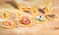 Raw dough and Italian homemade tortellini,open and closed,filled with ricotta cheese,shrimp,prosciutto,fresh spinach and walnuts.