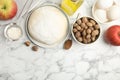 Raw dough, nutmeg seeds and other ingredients on white marble table, flat lay. Space for text Royalty Free Stock Photo